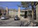 View of the condo exterior with assigned parking, stone accents, and private balconies under a clear blue sky at 4400 S Quebec St # C107, Denver, CO 80237