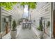 Outdoor dining area with string lights between modern siding, with potted trees between at 6058 Beeler Ct, Denver, CO 80238