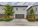 Two-story home with a brown garage door, flanked by small trees and low fences at 6058 Beeler Ct, Denver, CO 80238
