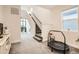 Bright hallway features carpeted stairs, large windows, and an open design with a mini trampoline at 6058 Beeler Ct, Denver, CO 80238