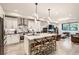 Bright, modern kitchen with a central island, stainless appliances, and integrated living area at 6058 Beeler Ct, Denver, CO 80238