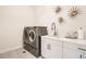 Modern laundry room features a stacked washer and dryer, ample white cabinetry, and stylish decor at 6058 Beeler Ct, Denver, CO 80238
