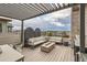 Stylish rooftop deck with a pergola, comfortable seating, and stunning city views at 6058 Beeler Ct, Denver, CO 80238