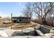 Backyard featuring a large patio area, seating, outdoor table, mature trees and storage shed at 2360 Estes St, Lakewood, CO 80215