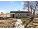 Exterior view of gray barn with shaded awning and gravel pathway on sunny day at 2360 Estes St, Lakewood, CO 80215