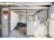 View inside an empty barn stall with sliding gate, storage, and natural light at 2360 Estes St, Lakewood, CO 80215