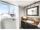 Compact bathroom with a sink vanity, large mirror, and window offering natural light at 2360 Estes St, Lakewood, CO 80215