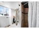 Modern bathroom with a tiled shower, decorative accents, and a bright window at 2360 Estes St, Lakewood, CO 80215