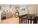 Bedroom with floral wallpaper, light wood floors, and a dark wood crib by a bright window at 2360 Estes St, Lakewood, CO 80215