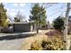 Home with detached garage with a gravel driveway and mature landscaping and greenery at 2360 Estes St, Lakewood, CO 80215