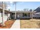 Single story home with gray brick exterior, dark shutters, and a well-manicured lawn at 2360 Estes St, Lakewood, CO 80215