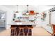 Modern kitchen with a center island, stylish lighting, copper range hood and open shelving at 2360 Estes St, Lakewood, CO 80215