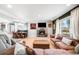 Bright and airy living room featuring a fireplace and an open floor plan with dining area at 2360 Estes St, Lakewood, CO 80215