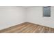A bright bedroom features light wood floors and a glass block basement window at 2616 W 134Th Cir, Broomfield, CO 80020