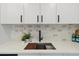 Modern kitchen sink with white cabinets, stylish backsplash, and sleek black fixtures at 2616 W 134Th Cir, Broomfield, CO 80020