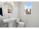 Powder room featuring a pedestal sink, toilet, and a window letting in natural light at 12273 Karls Ln, Northglenn, CO 80241