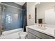 Modern bathroom with blue tiled walls, white vanity, and gold fixtures at 12273 Karls Ln, Northglenn, CO 80241