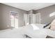 A well lit bedroom features a walk-in closet, light grey walls and white carpet at 12273 Karls Ln, Northglenn, CO 80241