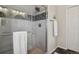 Bathroom featuring a tiled shower with a glass door and stone flooring at 16164 E Hinsdale Ave, Aurora, CO 80016