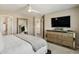 Bright bedroom featuring a ceiling fan, mirror, a large dresser with a TV at 16164 E Hinsdale Ave, Aurora, CO 80016