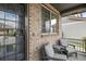 Cozy front porch with seating, brick accents, and a secure front door at 16164 E Hinsdale Ave, Aurora, CO 80016