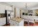 Open kitchen layout with granite island, stainless steel refrigerator, and view into the living space at 16164 E Hinsdale Ave, Aurora, CO 80016