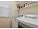 Functional laundry room with shelving and modern washer and dryer at 16164 E Hinsdale Ave, Aurora, CO 80016