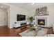 Inviting living room with fireplace, tv, and wood floors at 16164 E Hinsdale Ave, Aurora, CO 80016
