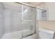 Clean bathroom features a tub with sliding glass doors and tiled walls at 13343 E Louisiana Ave, Aurora, CO 80012