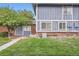 Exterior elevation of home with brick and blue siding on a grassy lawn at 13343 E Louisiana Ave, Aurora, CO 80012