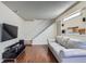 Cozy living room with hardwood floors, a comfortable sofa, and access to the staircase at 13343 E Louisiana Ave, Aurora, CO 80012