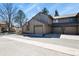 Exterior view of townhome showcasing garage doors and neutral siding under a sunny sky at 10732 W Florida Ave # B, Lakewood, CO 80232