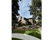 Townhome exterior featuring unique architecture, lush landscaping, and mature trees at 10732 W Florida Ave # B, Lakewood, CO 80232