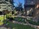 Well-manicured front yard with lush greenery, mature trees, and stone accents at 10732 W Florida Ave # B, Lakewood, CO 80232