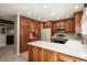 Bright kitchen featuring cherry cabinets, white appliances, and tile floors at 10732 W Florida Ave # B, Lakewood, CO 80232