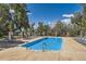 Community pool area with a sparkling blue pool surrounded by lounge chairs and mature trees at 10732 W Florida Ave # B, Lakewood, CO 80232