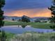 Stunning sunset view overlooking a golf course, pond, and mountain range at 10541 Leonardo Pl, Littleton, CO 80125