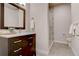 Modern bathroom with dark vanity, frameless shower, and marble top at 10541 Leonardo Pl, Littleton, CO 80125