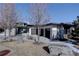 Modern home with stone exterior, wood garage doors, and mature trees at 10541 Leonardo Pl, Littleton, CO 80125