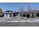 Contemporary home with stone and stucco exterior, and a snow-covered driveway at 10541 Leonardo Pl, Littleton, CO 80125