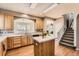 Bright kitchen features hardwood floors, countertops, island and access to the living room and staircase at 14652 Beeler St, Brighton, CO 80602