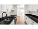 Galley kitchen featuring white cabinets, black countertops, and stainless steel appliances at 3315 S Monaco St # B, Denver, CO 80222