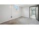 Empty bedroom featuring neutral paint, new carpet, a window, and open doorway at 5930 W 34Th Ave, Wheat Ridge, CO 80212