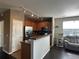Kitchen with stainless steel appliances and wood cabinetry adjoins a living space with gray furniture and wood floors at 7140 Simms St # 202, Arvada, CO 80004