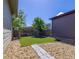 Private backyard featuring artificial grass, stone landscaping, and a fenced perimeter at 6682 Osage St, Denver, CO 80221