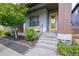 Inviting front entrance with a bright yellow door, well-maintained landscaping, and modern architectural details at 6682 Osage St, Denver, CO 80221