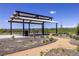 Modern pavilion with picnic tables offers outdoor dining with mountain views, surrounded by gravel paths and natural landscaping at 6682 Osage St, Denver, CO 80221