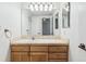 Bathroom vanity with wooden cabinets and a large mirror with vanity lighting at 969 S Pearl St # 103, Denver, CO 80209