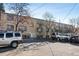 Three-story building with tan brick and a parking lot out front at 969 S Pearl St # 103, Denver, CO 80209