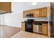 Kitchen featuring wood cabinets, granite countertops, and stainless-steel appliances with hardwood floors at 969 S Pearl St # 103, Denver, CO 80209